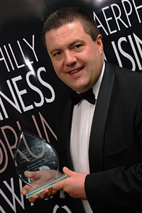 Andrew Diplock, Caerphilly Business Forum's newly elected chairman and commercial director of Ystrad Mynach-based firm UES, picks up his company's award in 2009