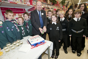 Store manager Paul Cartlidge cuts the cake with members of the 5th Risca Scouts and St John Ambulance