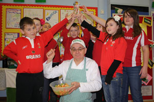 pupils from Hengoed Primary School congratulating their Cook-in-Charge Colin Jones on receiving his award