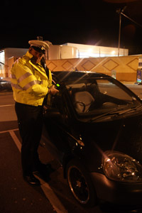 A police officer checks a car at Blackwood Asda