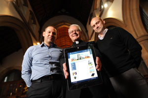 Jeff Lewis, left, and Simon Lewis, right, with Caerphilly Parish Rector Canon Robert Donkin and the website that Space on White has set up for the parish.