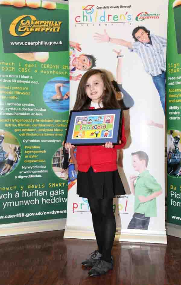 Emma Davies from Glyn Gaer Primary proudly shows off her artwork design