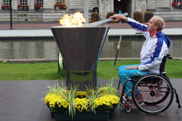 Paralympian cyclist Simon Richardson lights the cauldron. Photography by Carl Jones