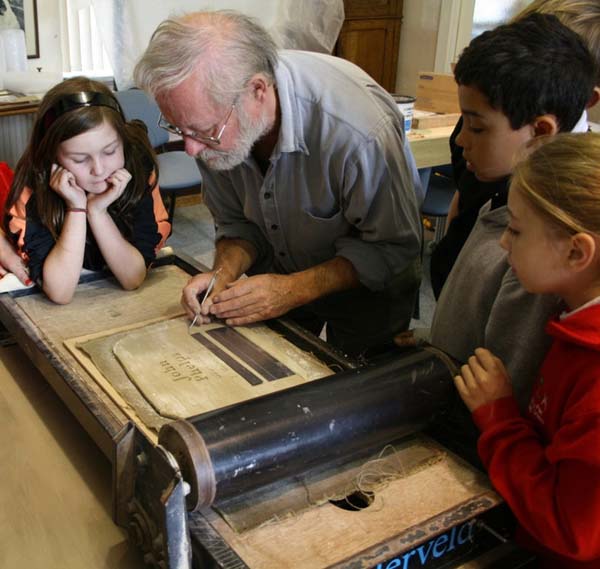 Pupils from year 6 at Nant-Y-Parc help Ned Heywood create a name tile in memory of John Phelps, one of the miners who died in one of the explosions at Universal Colliery