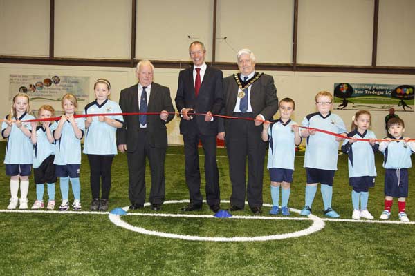 Children from Brithdir Bluebirds FC help the Minister for Culture and Sport, the Mayor of Caerphilly County Borough Council and Cllr Dave Poole cut the ribbon.