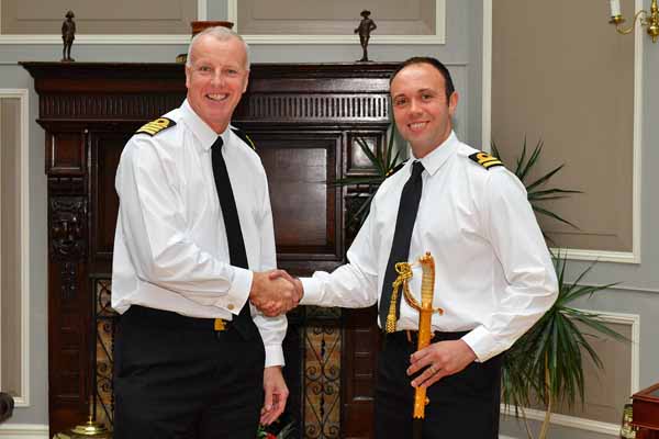 Captain Neil Wagstaff presents the sword to Steven Andrews (right)