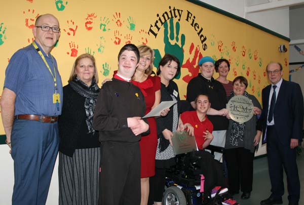 PRAISED: Headteacher Ian Elliott (left) with pupils, staff, and council education bosses
