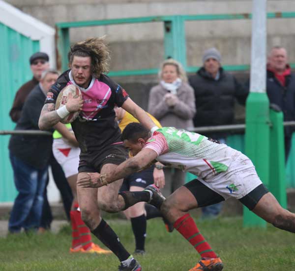 Scorpions winger Dai Evans tried to fend off a Cougars tackler