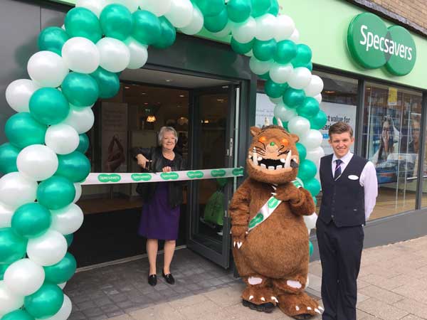 Specsavers co-founder, Dame Mary Perkins cuts the ribbon to open the new shop in Caerphilly town