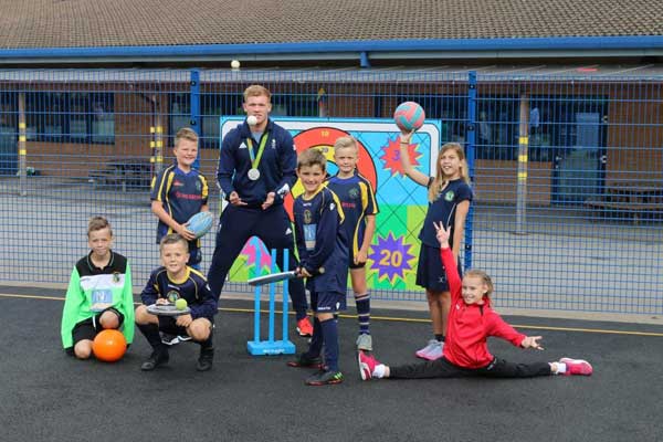 CATCH: Olympic gold medallists Sam Cross with Rhiw Syr Dafydd Primary School pupils on their new Multi-Use Games Area