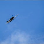 A Spitfire wartime plane flies over Armed Forces Day. Photo by Carl Jones