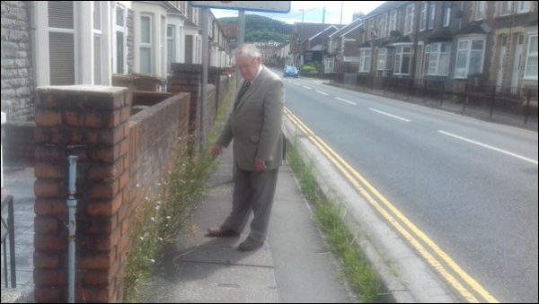 Plaid Cymru's Cllr Phil Bevan before the weeds were cleared by Caerphilly County Borough Council