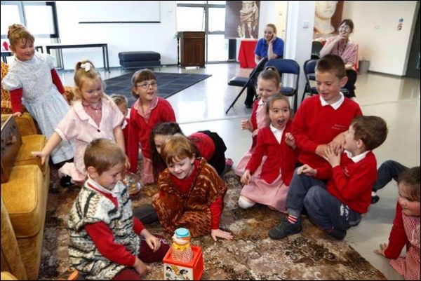 Children visiting the museum learning about old toys