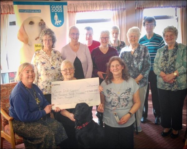 Members of Young at Heart and Friends in Trethomas present their cheque to Guide Dogs Cymru