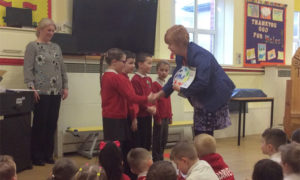 Sue Davies, Director of Investors in Families, presents the award to the pupils of Cwmaber Infants School
