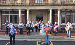 Knitting volunteers with their blankets outside Caerphilly Miners' Centre