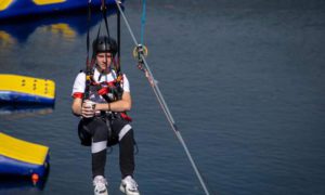 Finlay Williams on the zipwire holding a cup of tea