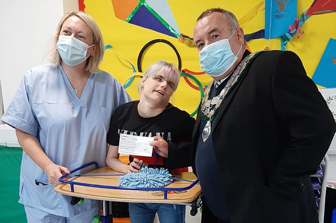 Caerphilly town mayor Cllr Mike Prew presents a cheque to Sense Cymru