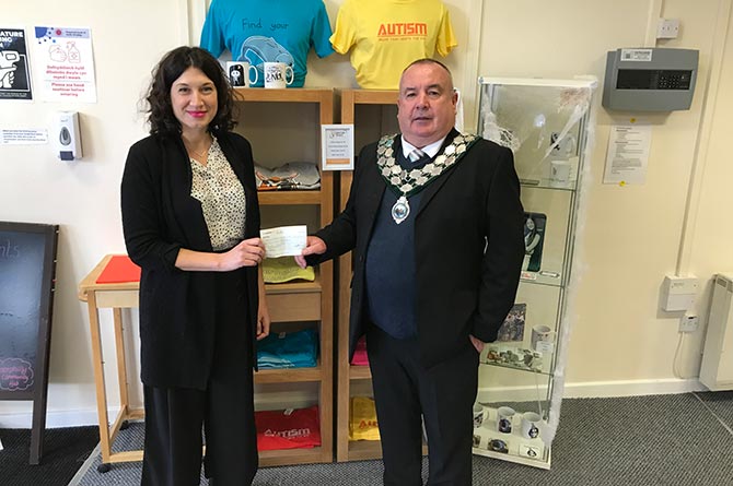 Caerphilly town mayor Cllr Mike Prew presents a cheque to Sarah Cutting of Autistic Minds