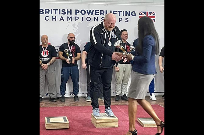Dylan Davies stands on the podium after winning the British Powerlifting Championships in Lincolnshire