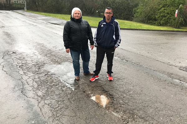 Rebecca and Dean Yearsley stood next to the pothole-covered road entering Kingsmead