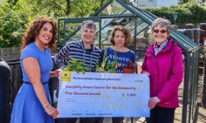 Sarah Edwards of the Thomas Carroll Group, left, presents a cheque to Chris O'Meara, Liz Paull and Katherine Hughes of Caerphilly Miners' Centre