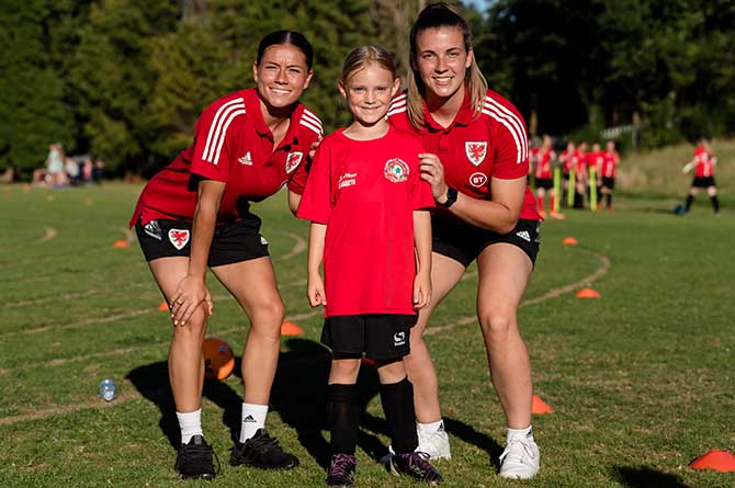 Ffion Morgan, left, and Olivia Clarke, right, with a young Caerphilly Dragons player