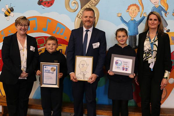 Education minister Jeremy Miles, centre, alongside Cllr Carol Andrews, left, headteacher Sharon Pascoe, right, and pupils