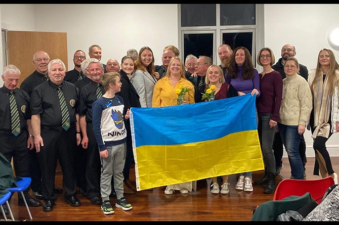 Members of Caerphilly Male Voice Choir with Ukrainian refugees at Caerphilly Miners' Centre
