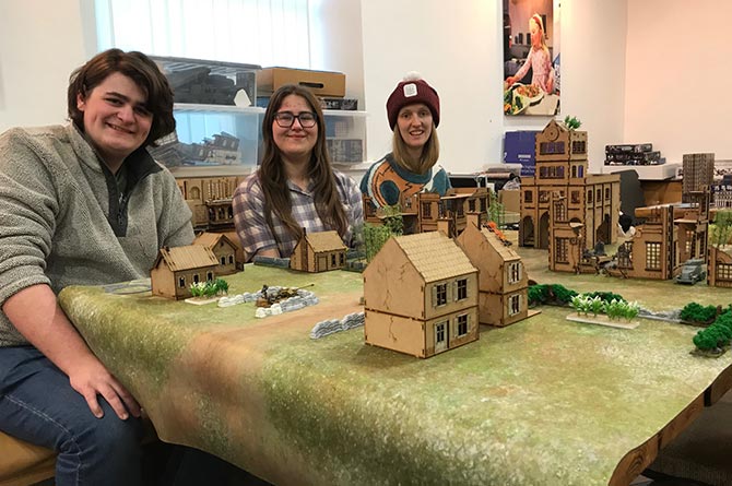 Jacob Mansell, Molly Morgan and Xanthe Maddocks with a model battlefield