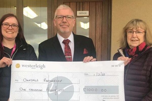 The Oakdale Partnership receiving a £1,000 cheque from Sirhowy Valley Crematorium