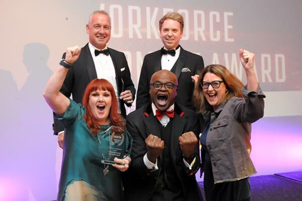 Caerphilly Council staff celebrating their award win with Kriss Akabusi