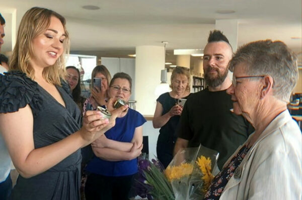Yulia Bond, left, presenting Jane Hutt MS with a symbolic trench candle
