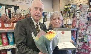 Lynn Hobbs, right, is presented with her long-service award from Post Office area manager Ceri James