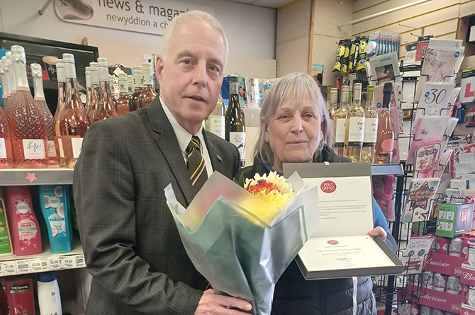 Lynn Hobbs, right, is presented with her long-service award from Post Office area manager Ceri James