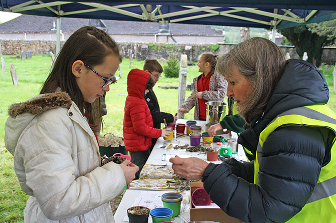 St Michaels and All Angels Volunteer and Bellringer Ann Ashburner helping a student make a Bug Hotel