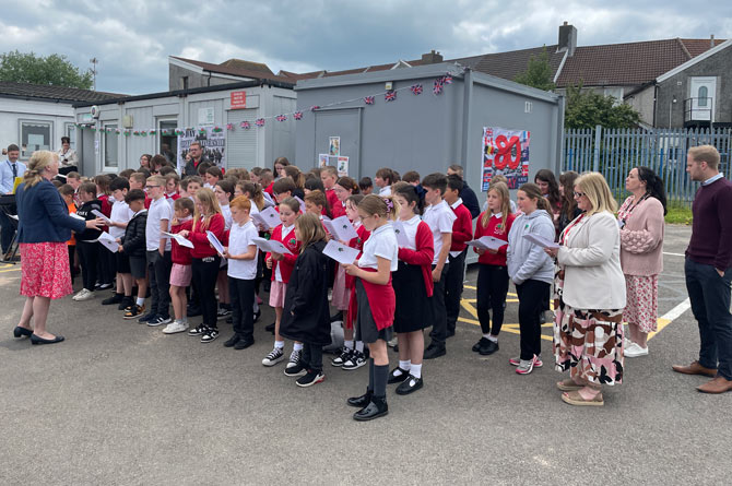 Pupils from Cefn Fforest Primary School singing outside the community hall