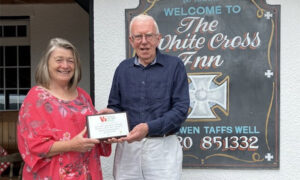 White Cross Inn landlady Mair Arthur is presented a cheque by Roger Belle, of Pub is the Hub