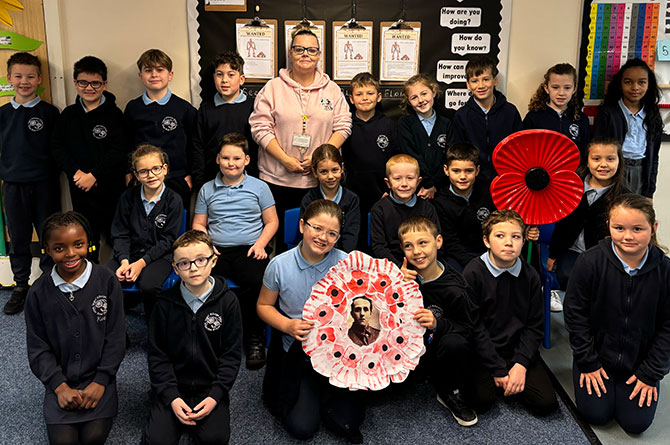 The children of White Rose Primary School with the poppy wreath they made in tribute to Pte Robert Phillips