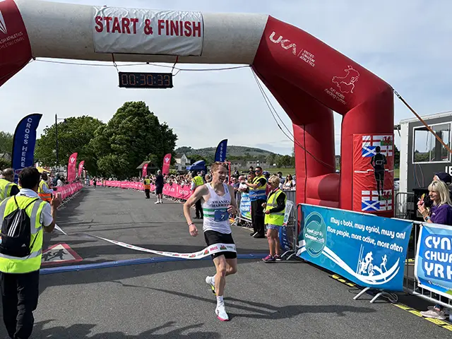 10k race winner Jonathan Butler crossing the finishing line