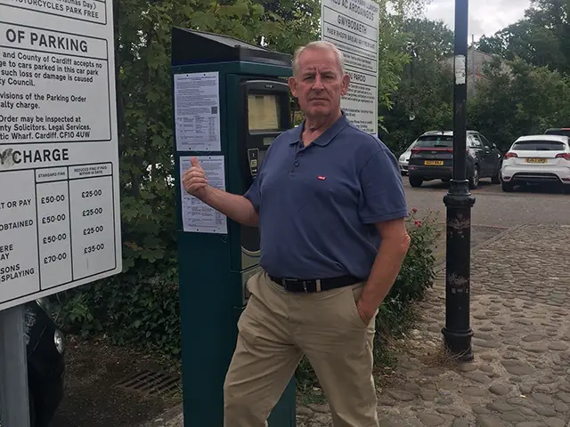 Cardiff councillor Sean Driscoll stood next to a car parking meter