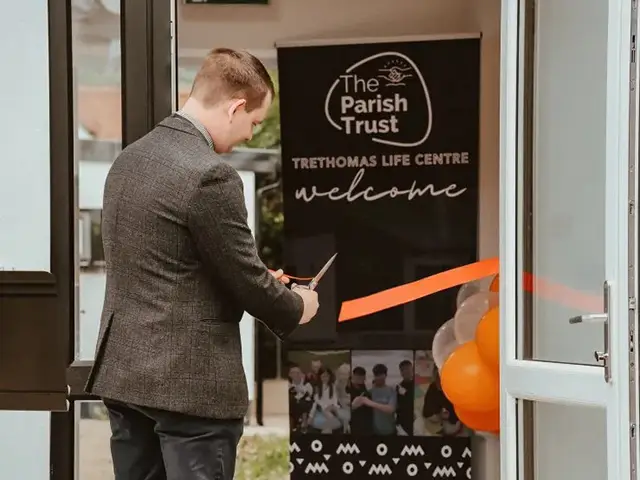Reverend Dean Roberts cutting the ribbon to officially open the Parish Trust's new base