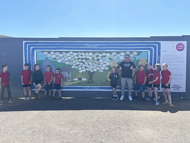 Chris Morgan with Ysgol Ifor Bach pupils at the new mural in Abertridwr