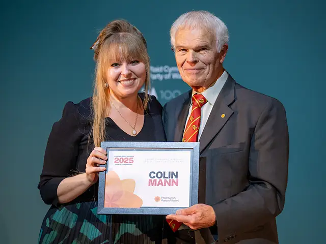 Plaid Cymru MS Delyth Jewell presenting Cllr Colin Mann with his contribution award