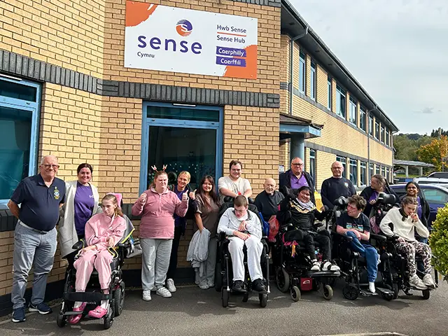 Users and staff at the Sense Cymru hub in Caerphilly, alongside members of the Caerphilly Lions Club