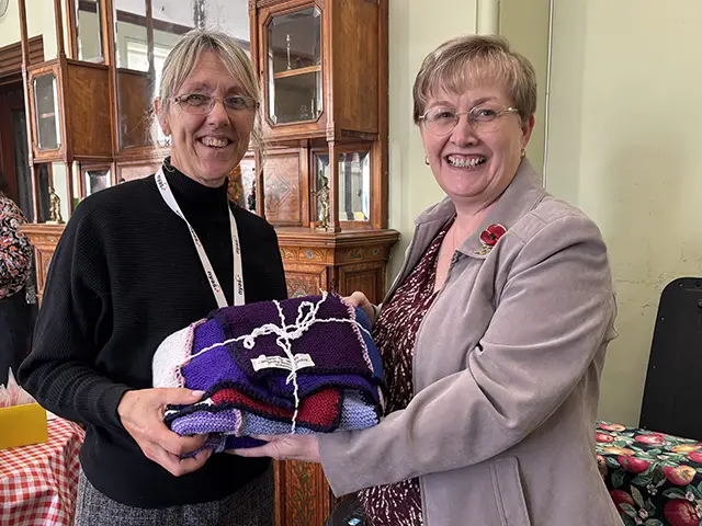 Cllr Carol Andrews, right, presenting a blanket to Sarah Macleod of NYAS