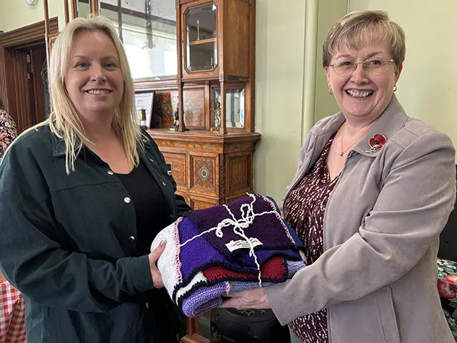 Rachel Haines, of the Parent Network, left, is presenting with a blanket by Cllr Carol Andrews