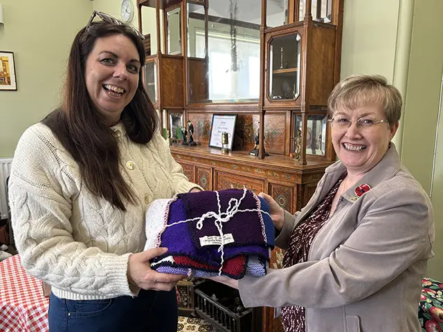 Caerphilly Uniform Exchange's Lisa Watkins, left, receiving a blanket from Cllr Carol Andrews