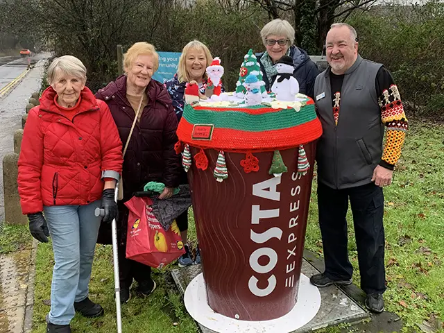 Machen WI members with Co-op store manager Stephen Willey next to the decorated coffee cup