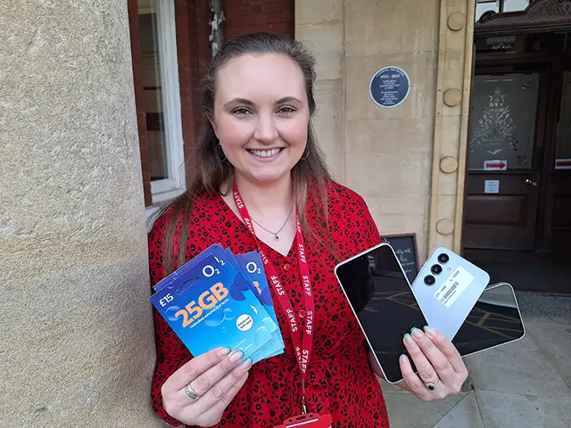 Sophie Davies, of Caerphilly Miners' Centre, with some of the phones and SIM cards being given away